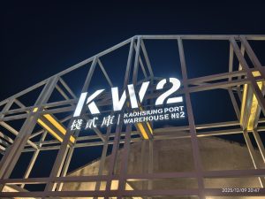 夜間駁二藝術特區倉庫建築上的KW2大型發光標誌與金屬框架結構