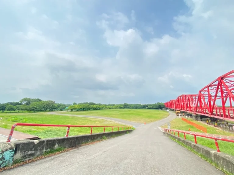 西螺大橋親水公園與螺石公園，紅色鋼桁架大橋橫跨綠地與河岸步道