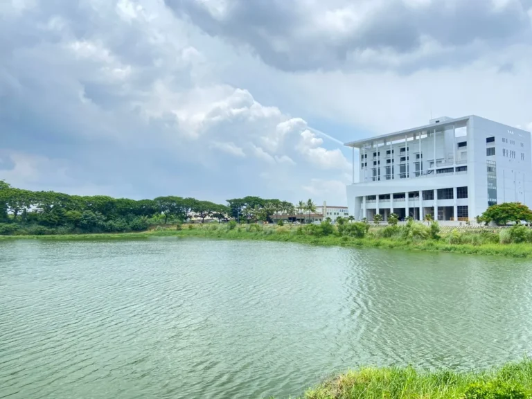 紫藤湖，碧綠湖水與多雲天空，遠岸矗立白色大樓