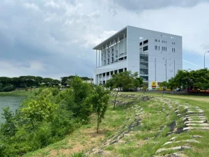 紫藤湖，多雲天空下白色現代建築矗立於湖畔綠坡上