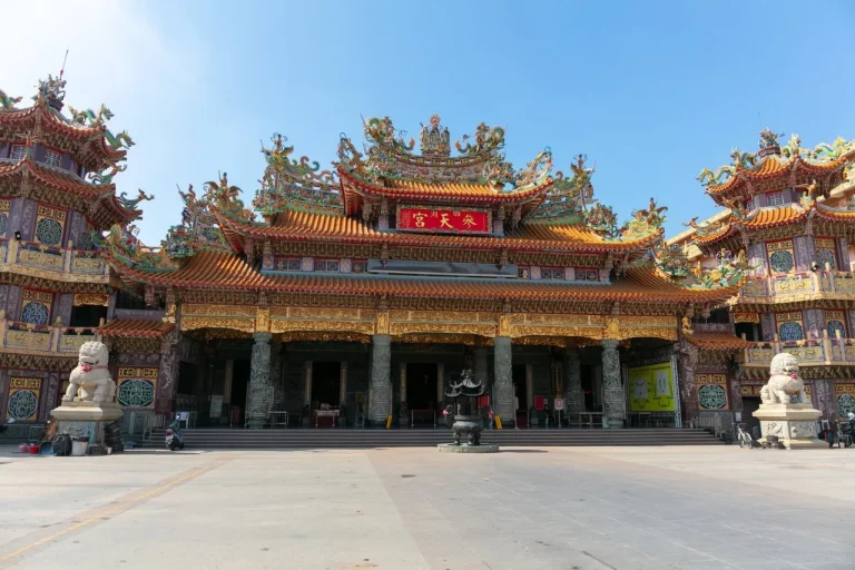 四湖參天宮正面，金黃琉璃瓦廟身搭配石獅，廣場開闊空蕩