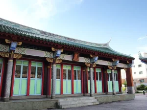 澎湖孔廟，綠瓦紅柱長廊與成排彩繪格扇門的側殿