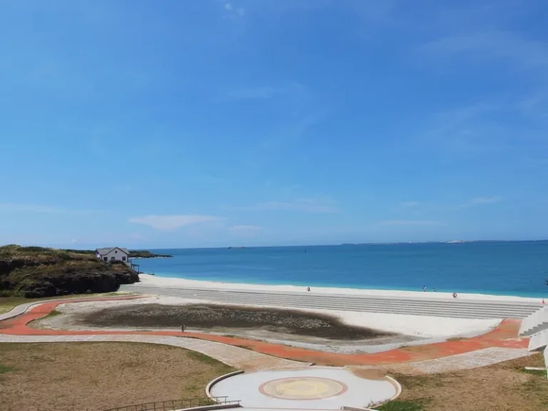 赤崁親水公園，潔白沙灘環抱蔚藍海灣，弧形階梯與步道延伸入海