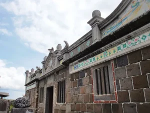 澎湖二崁陳家古厝，仰望玄武岩牆面與彩繪花磚裝飾的馬背山牆