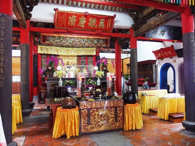 澎湖觀音亭正殿內部，紅柱神龕與鋪設黃布的供桌香爐