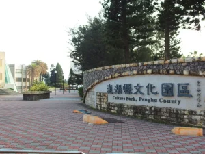 澎湖縣文化園區入口，弧形石牆上的園區名稱與廣場磚道