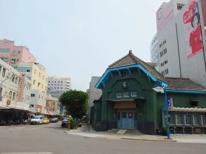 澎湖郵便局，街角綠牆老郵局建築與一旁的市街樓房