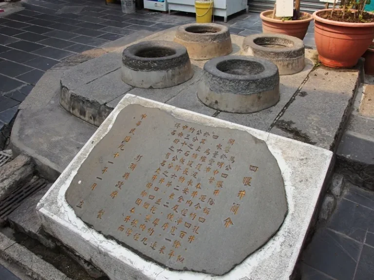 澎湖四眼井，四口圓形井口排列石板地，前方臥置刻字解說石碑