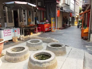 澎湖四眼井，老街石板路上四口圓井並列，兩側商店林立