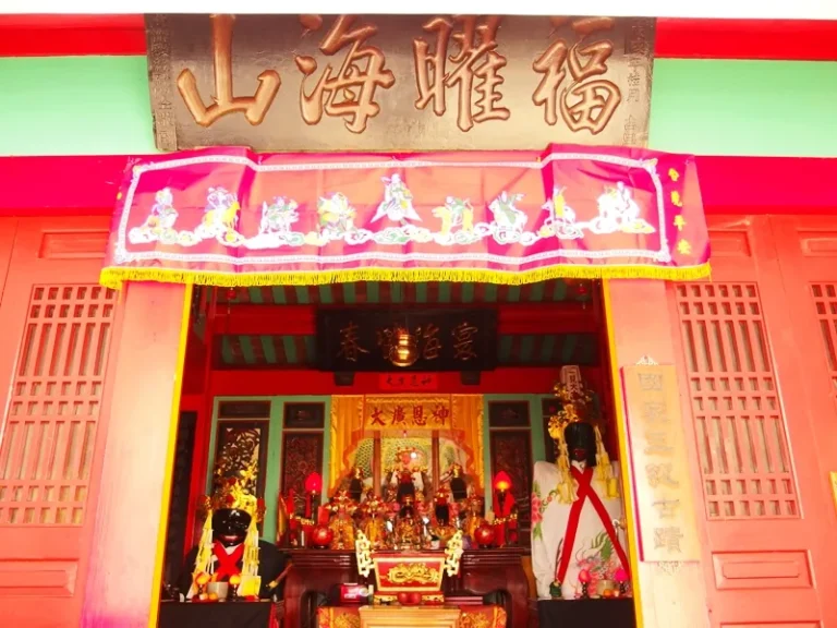 澎湖施公祠，紅牆廟內神龕供奉眾神像，上方懸掛福曜海山匾額