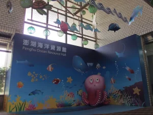 澎湖海洋資源館入口主題牆，海洋生物彩繪與粉紅章魚立體裝置