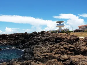 澎湖風櫃洞，嶙峋玄武岩海岸後方的白色聽濤觀景台地標