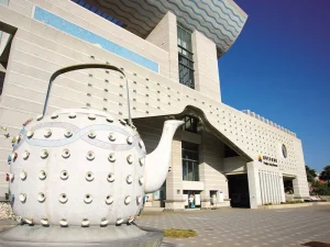 澎湖生活博物館戶外造景，藍天下巨型茶壺地景雕塑佇立館前廣場