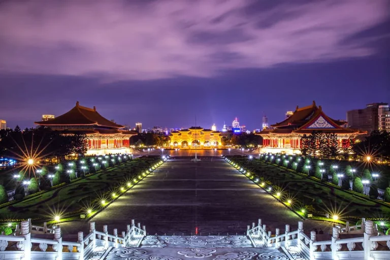 國立中正紀念堂，夜色中自由廣場牌樓與兩廳院燈火通明、步道燈光延伸