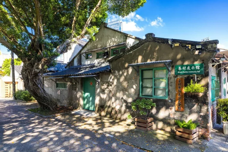 信義公民會館暨眷村文化公園四四南村，老樹下灰瓦平房與綠色木門眷舍