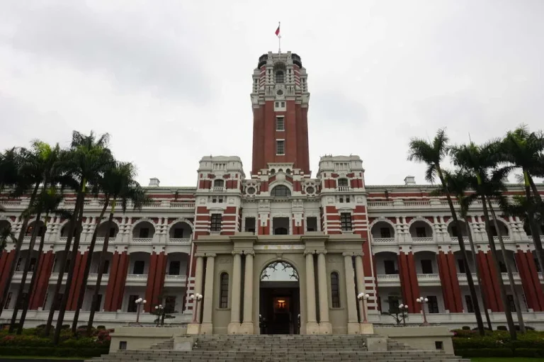 中華民國總統府，紅白相間巴洛克立面與高聳中央塔樓，前列椰影