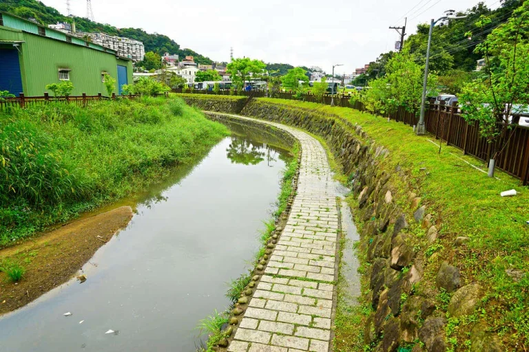 內溝溪生態步道，溪畔石砌駁坎旁石板小徑蜿蜒穿過綠意