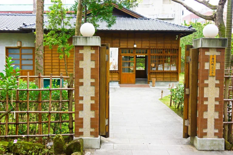 臺北市南門町三二三，磚柱門柱後方綠樹掩映的日式木造平房