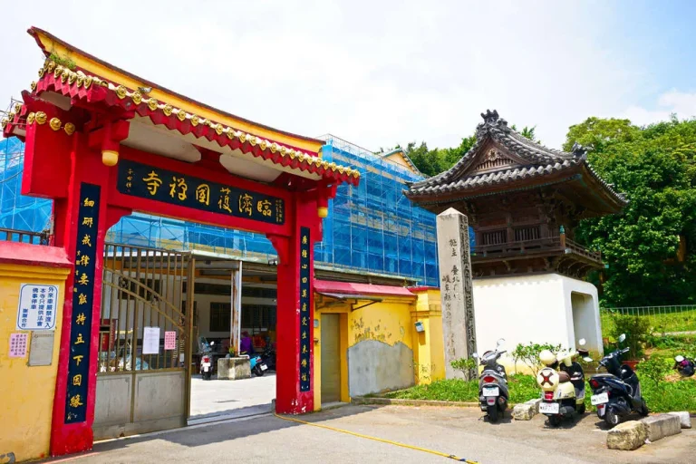 臺北市臨濟護國禪寺，紅金山門牌樓與一旁古樸木造鐘樓