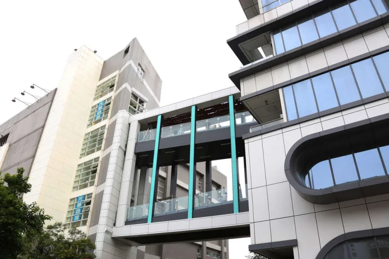 臺北市三創生活，玻璃帷幕大樓間以藍柱空橋相連的現代建築