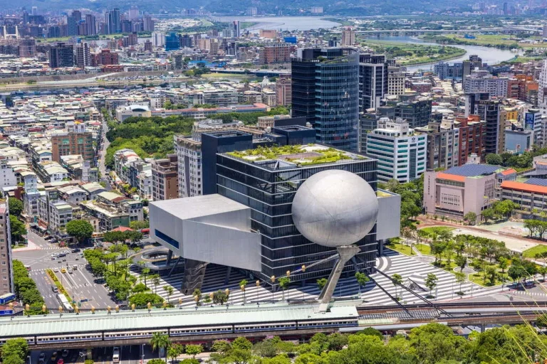 臺北表演藝術中心嵌入球形量體的灰色建築，俯瞰士林街區與河景