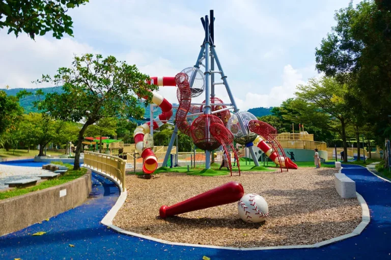 天母夢想樂園棒球主題遊戲場，紅色溜滑梯塔架與球棒球造景立於山腳