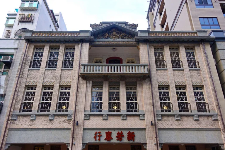 新芳春茶行仿巴洛克式立面老建築，三層連續拱窗與中央陽台典雅