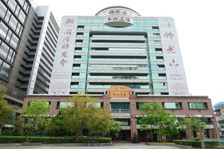 佛光山台北道場，外牆題字的高樓大廈聳立於綠樹庭園之後