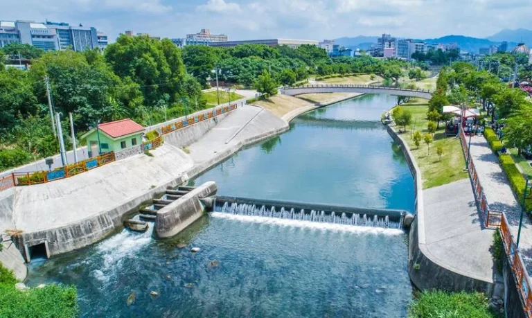 興大康橋，空拍水圳攔水堰激起白色水花與兩岸綠地步道