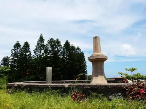 林投公園，草地上的石造紀念碑與成排尖塔狀的南洋杉