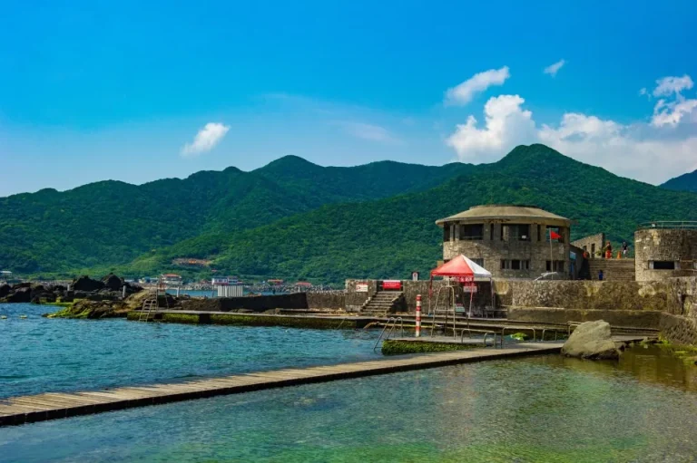 龍洞灣海洋公園，碧海環繞的圓形碉堡建築與礁石海岸，遠處群山連綿