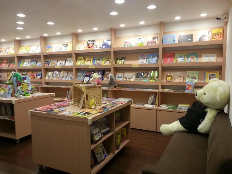 艾比露比外文書店，木質書架陳列繪本與沙發上的大白熊玩偶